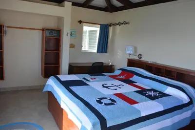a bedroom with a bed with a colorful quilt on it at SERENDIPITY in Virgin Gorda