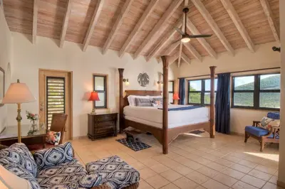a bedroom with a bed and a couch at A DREAM COME TRUE VILLA in Virgin Gorda