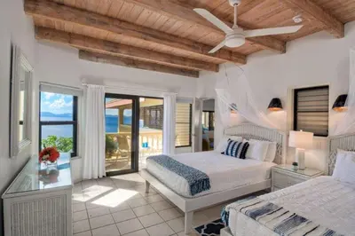 a bedroom with two beds and a ceiling fan at A DREAM COME TRUE VILLA in Virgin Gorda