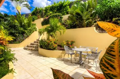 a patio with a table and chairs and plants at A DREAM COME TRUE VILLA in Virgin Gorda