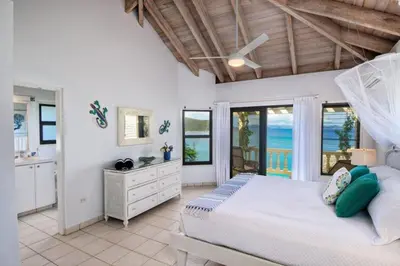 a bedroom with a bed and a view of the ocean at A DREAM COME TRUE VILLA in Virgin Gorda