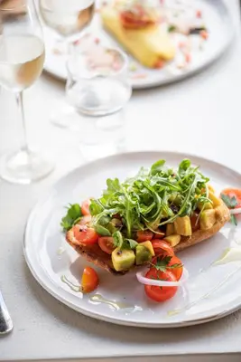 a white plate with a sandwich with vegetables on it at Long Bay Beach Resort in Tortola Island