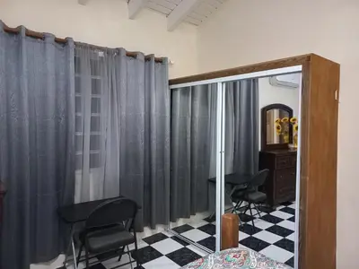 a room with gray curtains and black chairs and a table at More Than Beauty Properties in Tortola Island
