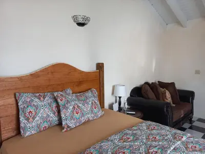 a bedroom with a bed with pillows and a couch at More Than Beauty Properties in Tortola Island