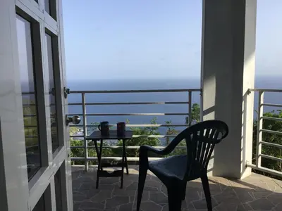 a chair and a table on a balcony with a view at Abigail's Spectacular 2 bedrooms-Entire Apartment in Tortola Island