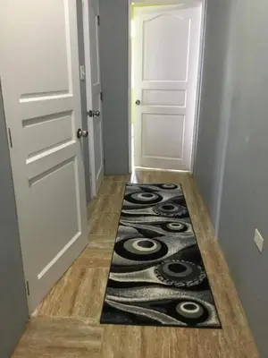 a hallway with a rug on the floor next to a door at Abigail's Spectacular 2 bedrooms-Entire Apartment in Tortola Island