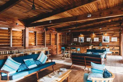 a living room with wooden walls and blue couches at Bitter End Yacht Club in Virgin Gorda