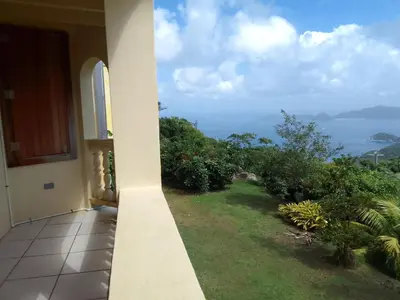 a balcony of a house with a view of the ocean at Abigail's Sunflower Entire 2 Bedroom Apt in Tortola Island