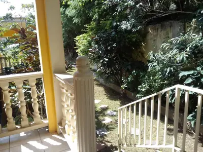 a porch with a white railing and a staircase at Abigail's Sunflower Entire 2 Bedroom Apt in Tortola Island